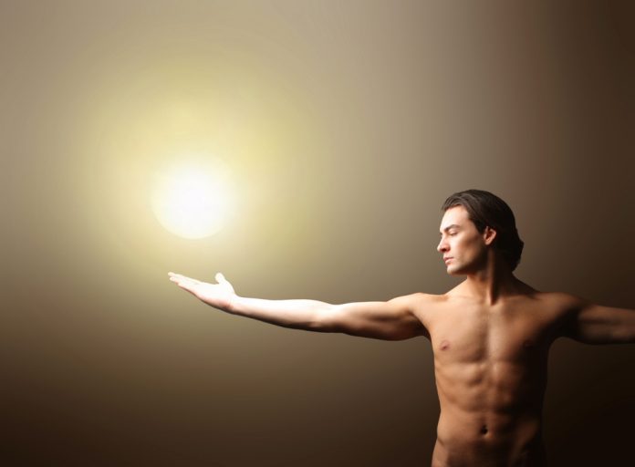 a nude man with a light on his hand