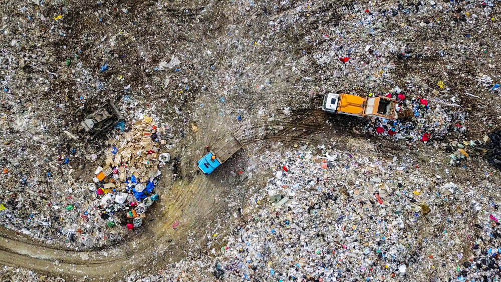 Garbage trucks unload garbage to a landfill