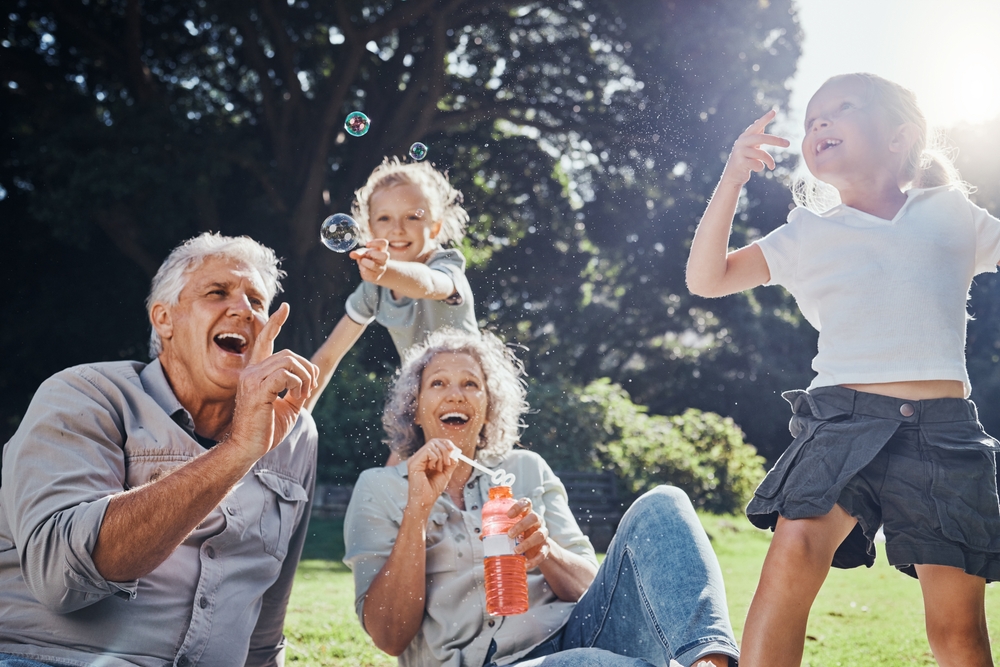 Grandparents and kids playing with bubbles in the park