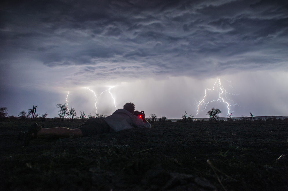 man photographing lightning
