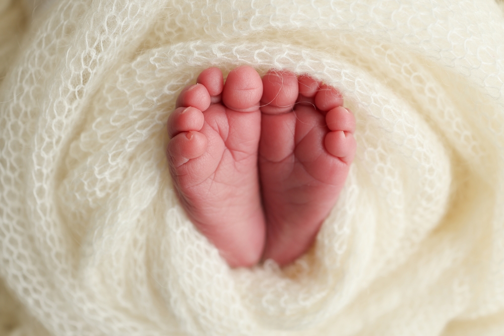Newborn Baby feet wrapped in a white blanket