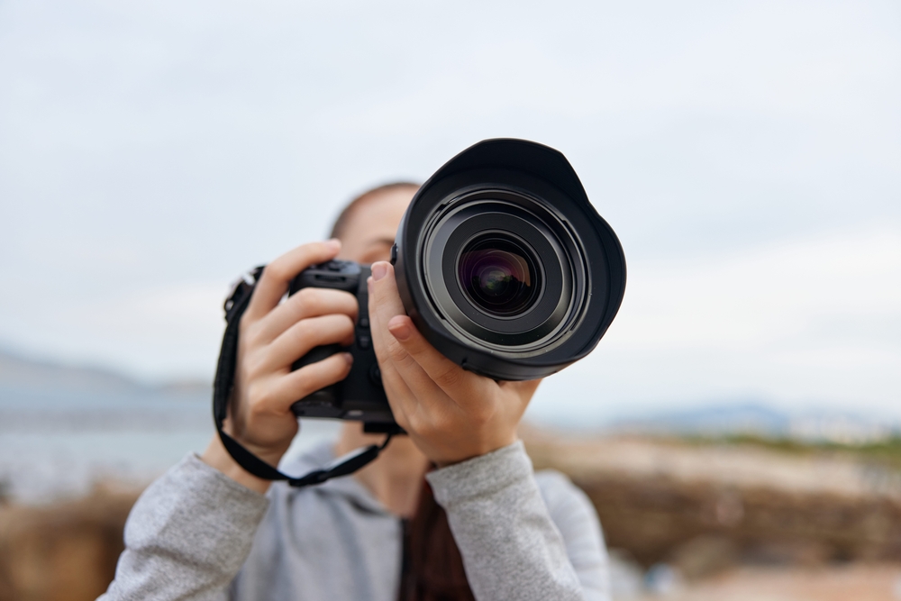 photographer holding a camera on a cloudy day