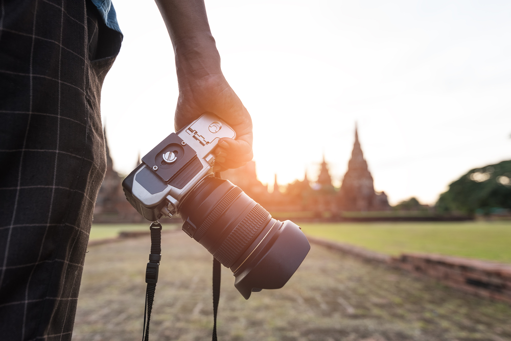 photographer holding a camera with a zoom lens