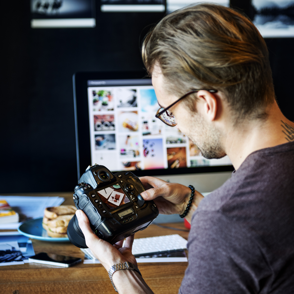 photographer looking at images on the back of his camera