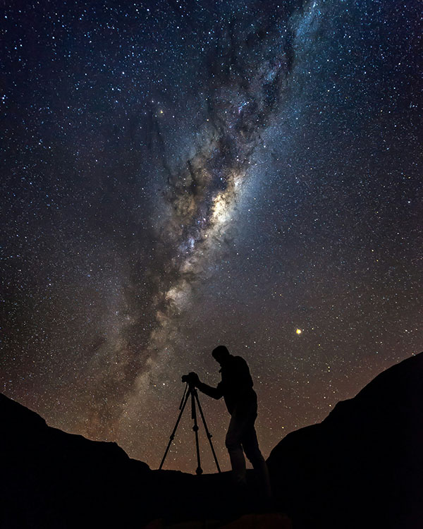 photographer silhouette against milky way