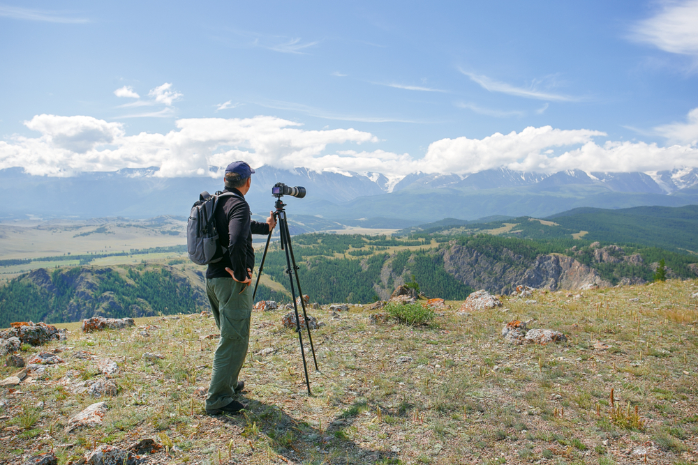 photographer taking nature photos of mountain landscape