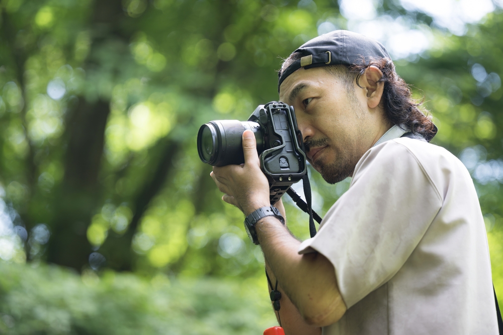 Photographer with SLR camera outdoors in summer