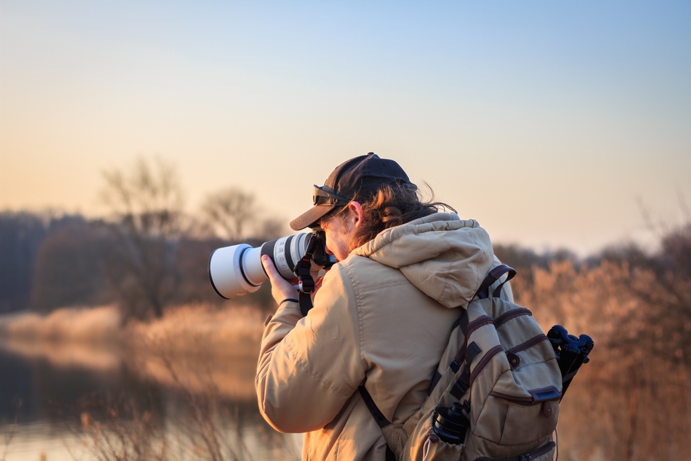 Wildlife photographer with camera and telephoto lens