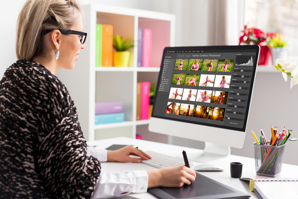 Woman editing photos on a desktop computer